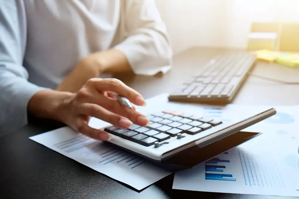 Travail comptable sur ordinateur avec documents fiscaux et calculatrice
