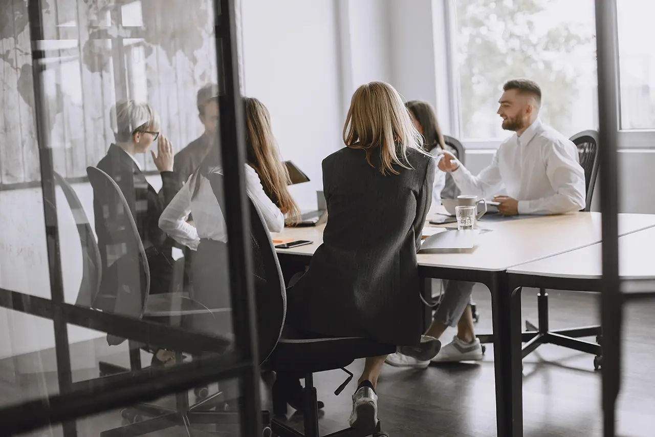 Bureau convivial d’un cabinet comptable avec échanges de documents entre collègues